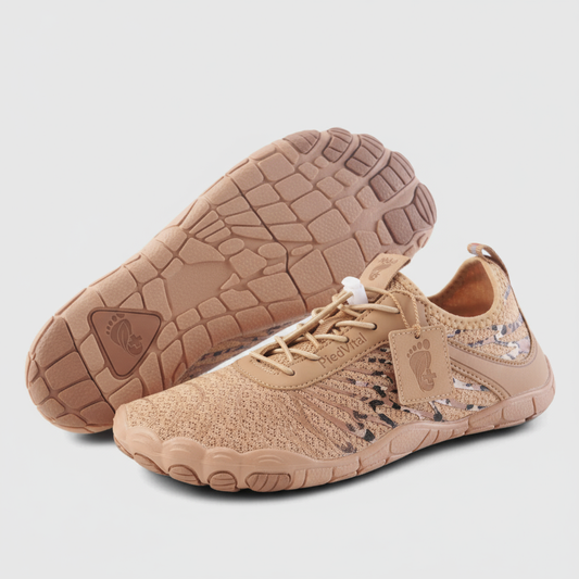A pair of tan-colored athletic shoes with a textured sole and a tag attached to the lace.